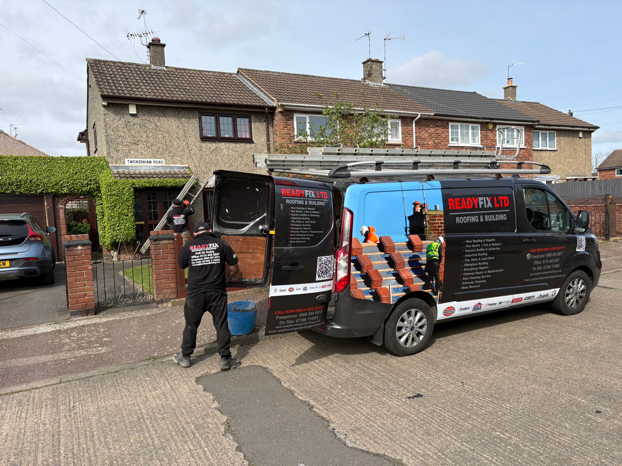 ReadyFix van and team carrying out a full roof replacement on a residential street